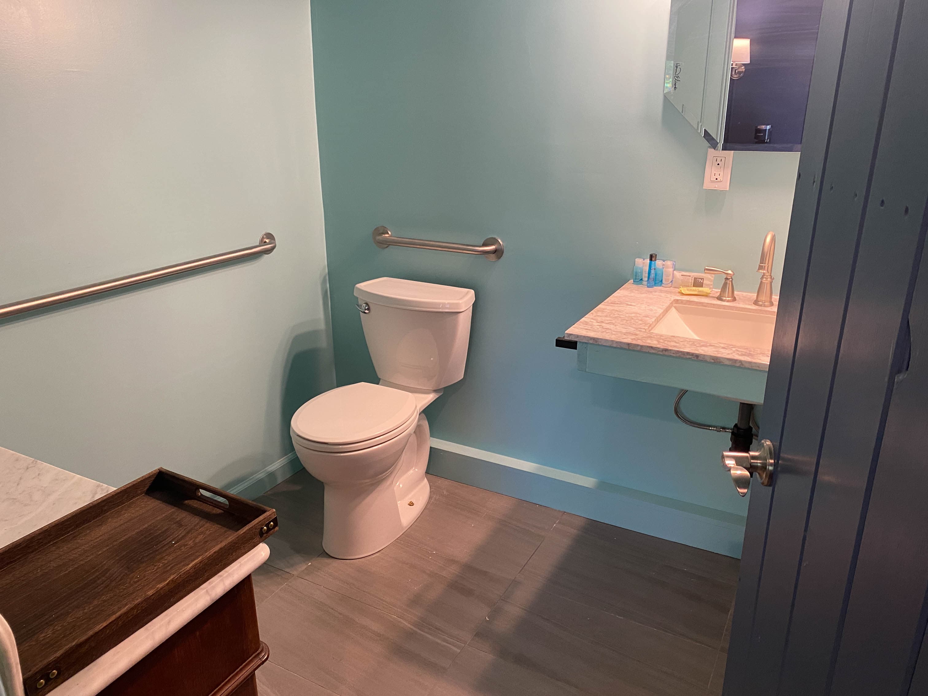 modern handicap accessible bathroom with grab bar by toilet and blue walls
